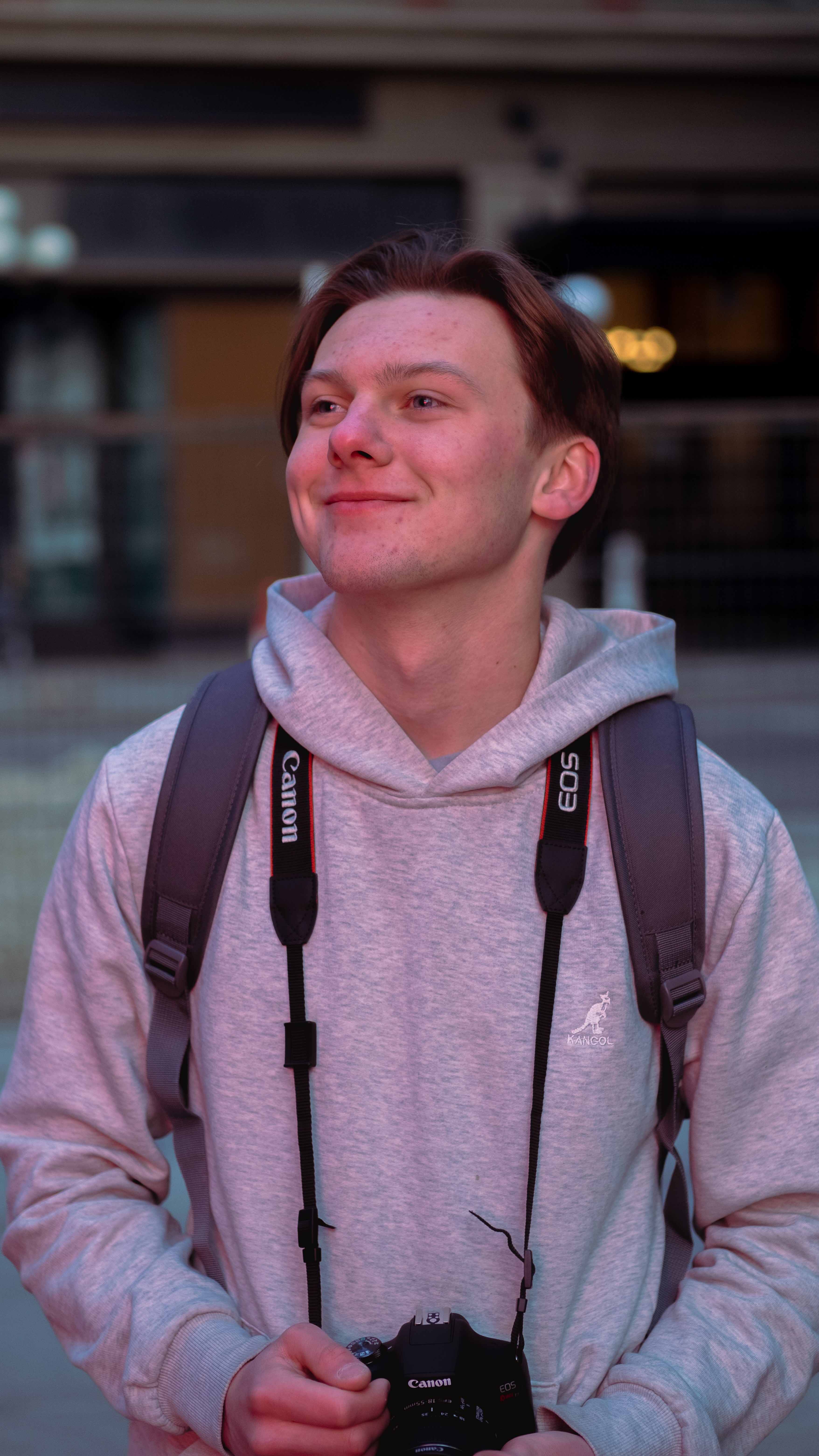 Aiden Johner Holding a camera looking to the left of the frame.